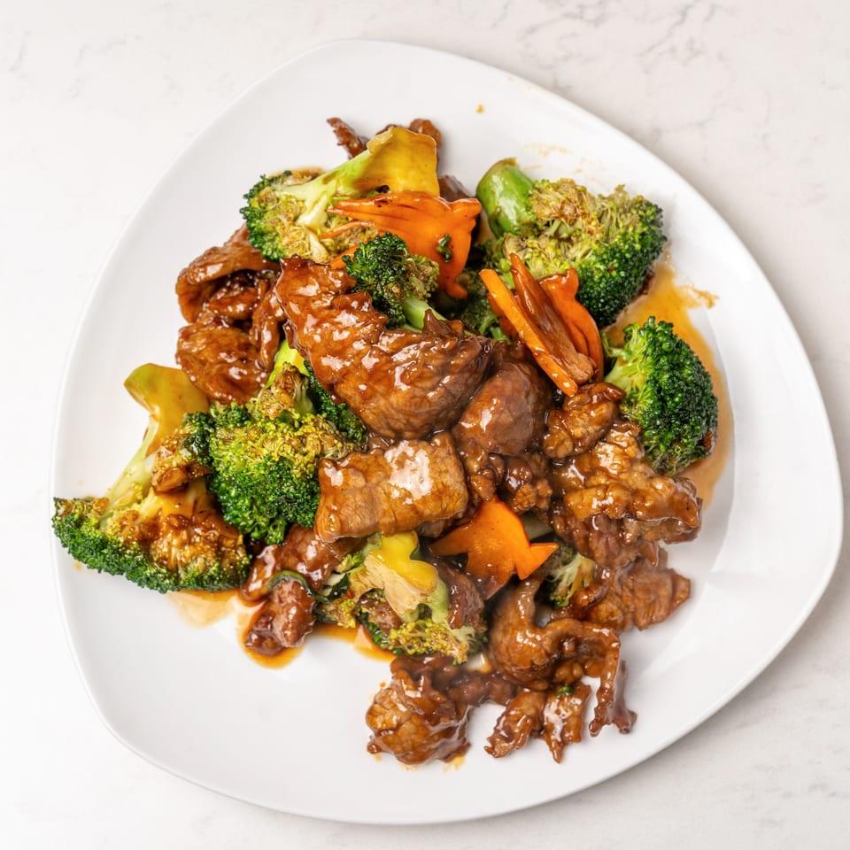 Mei Lai Xuan's beef and broccoli stir-fry with carrots and a rich brown sauce on a white plate.