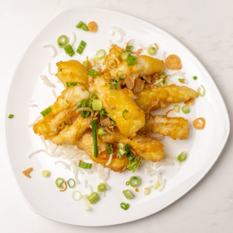 Golden-fried calamari with scallions and crispy garlic on a white plate at Mei Lai Xuan.