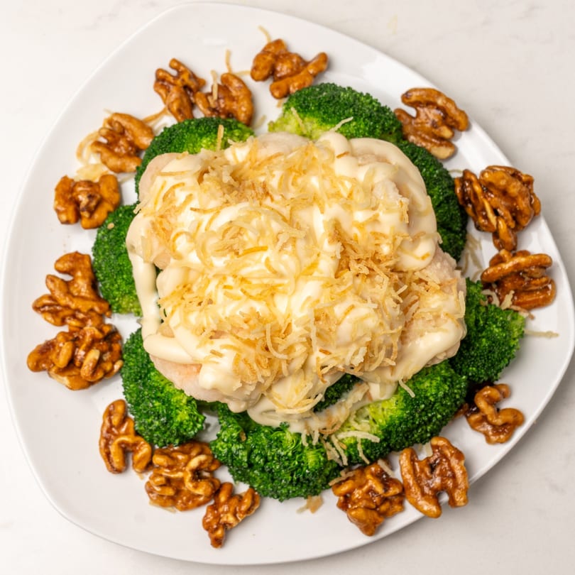 Mei Lai Xuan's honey walnut shrimp with broccoli and crispy noodles on a white plate.