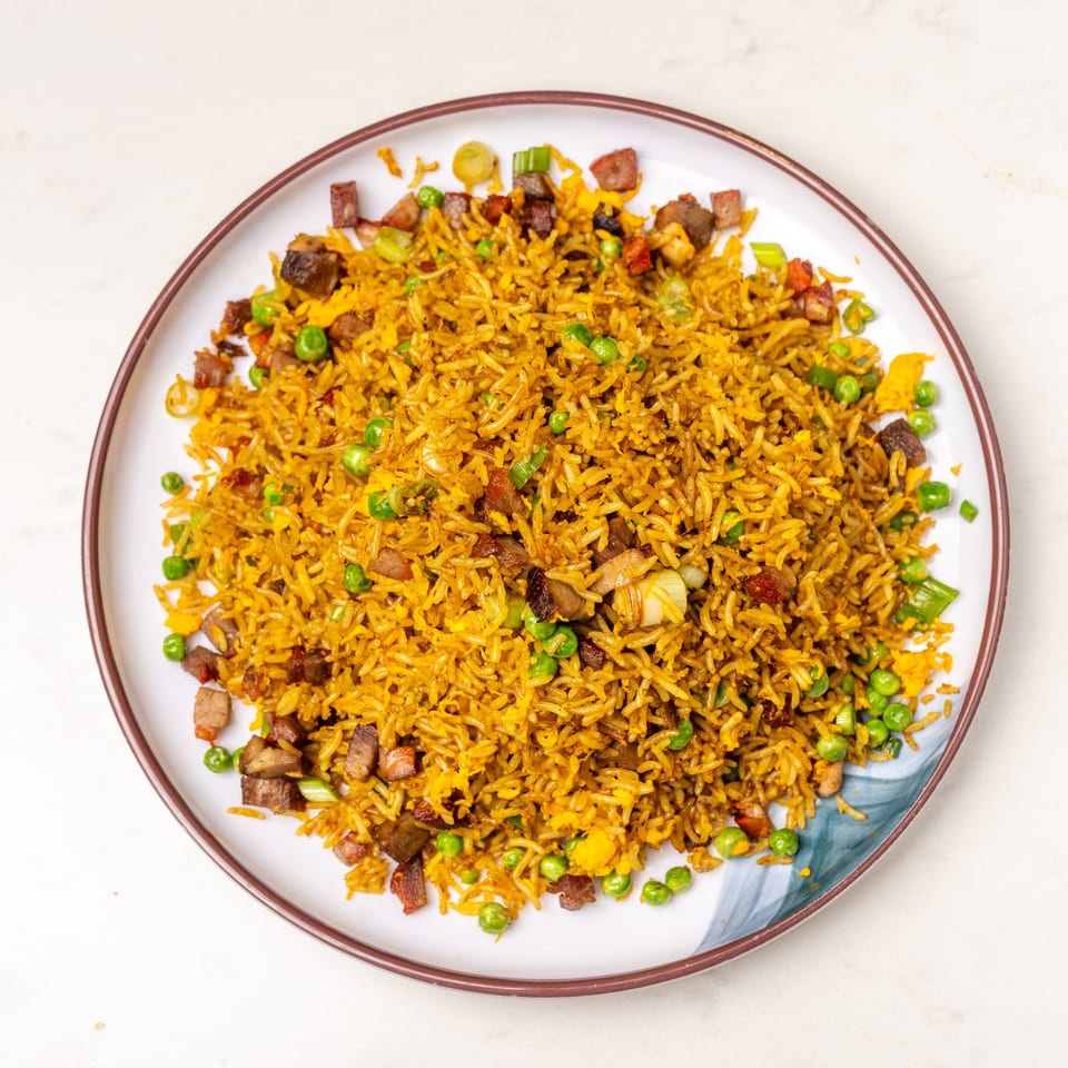 Mei Lai Xuan's golden fried rice with peas, egg, and diced pork on a white plate.
